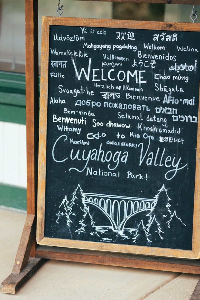 Chalkboard sign welcoming visitors to Cuyahoga Valley National Park in various languages.