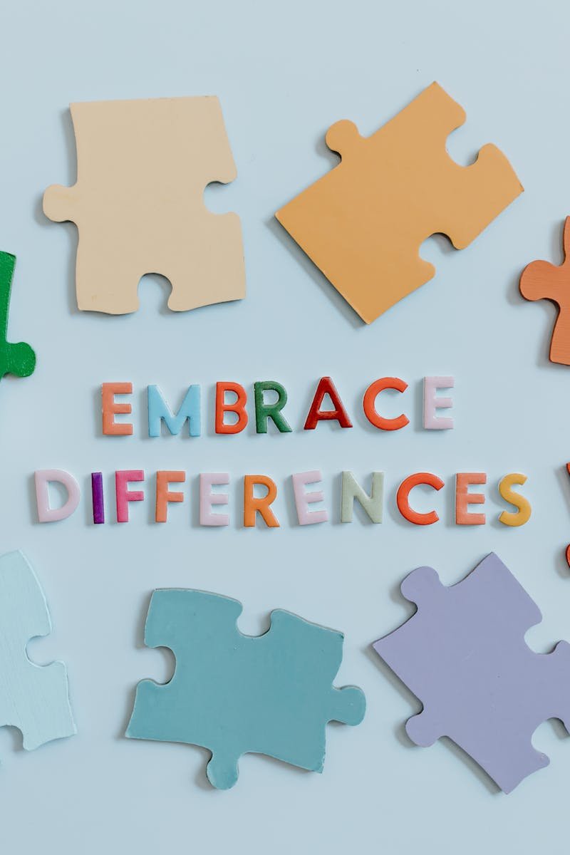 Colorful puzzle pieces surrounding 'embrace differences' text, symbolizing diversity and unity.