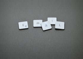 Close-up of the word 'email' formed with letter tiles on a gray surface.