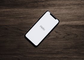 A smartphone displaying 'Hello' on a wooden surface, showcasing modern technology.