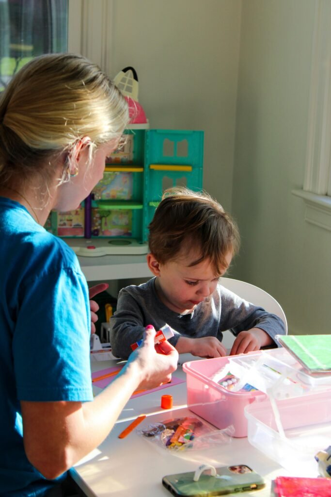 Home A young child involved in an arts and crafts session, fostering creativity and learning indoors.