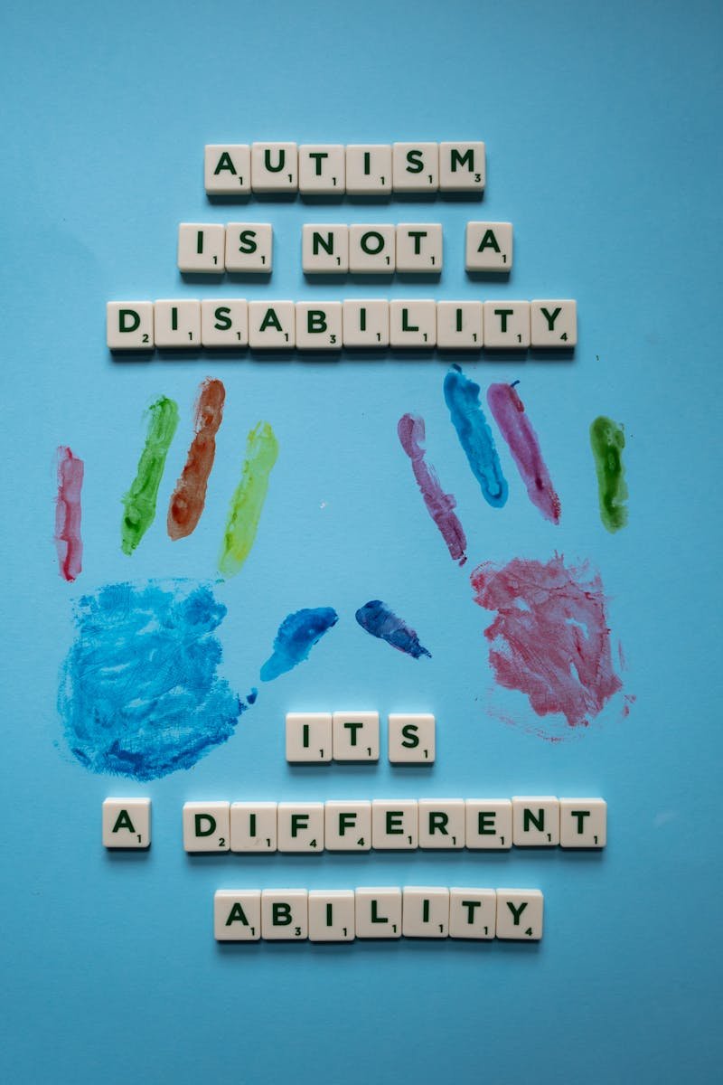 Home Creative composition with Scrabble tiles and paint promoting autism awareness and acceptance.